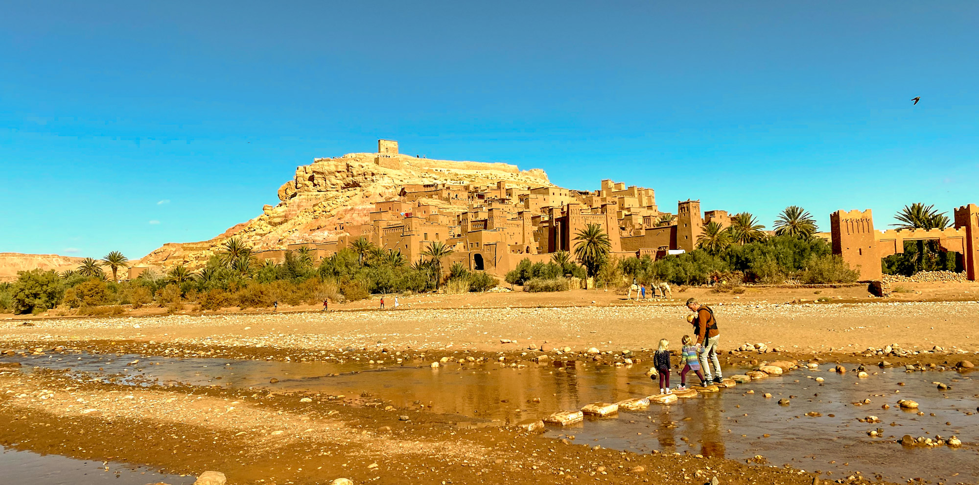Crossing river stepping stones to Ait Benhaddou, Morocco
