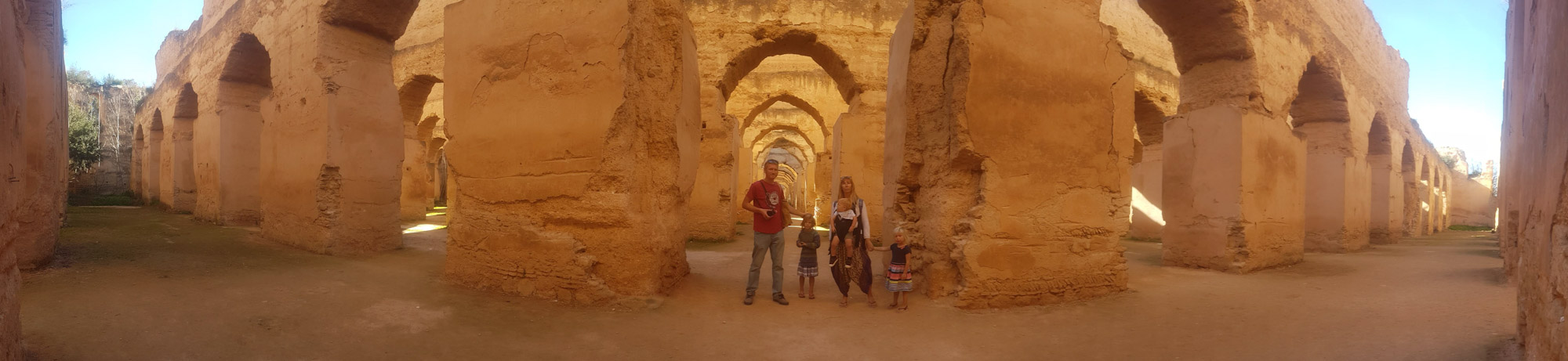 Family standing inside the ancient stables at Meknes, Morocco