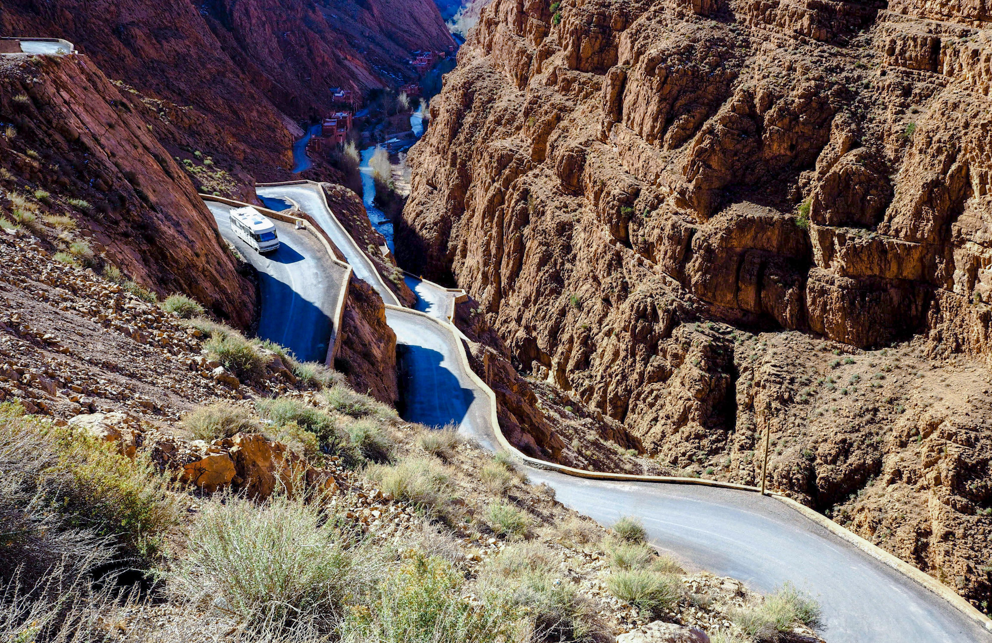 Classic Hymer motorhome descending hairpin bends down the mountain road through the Dades Gorge, Morocco