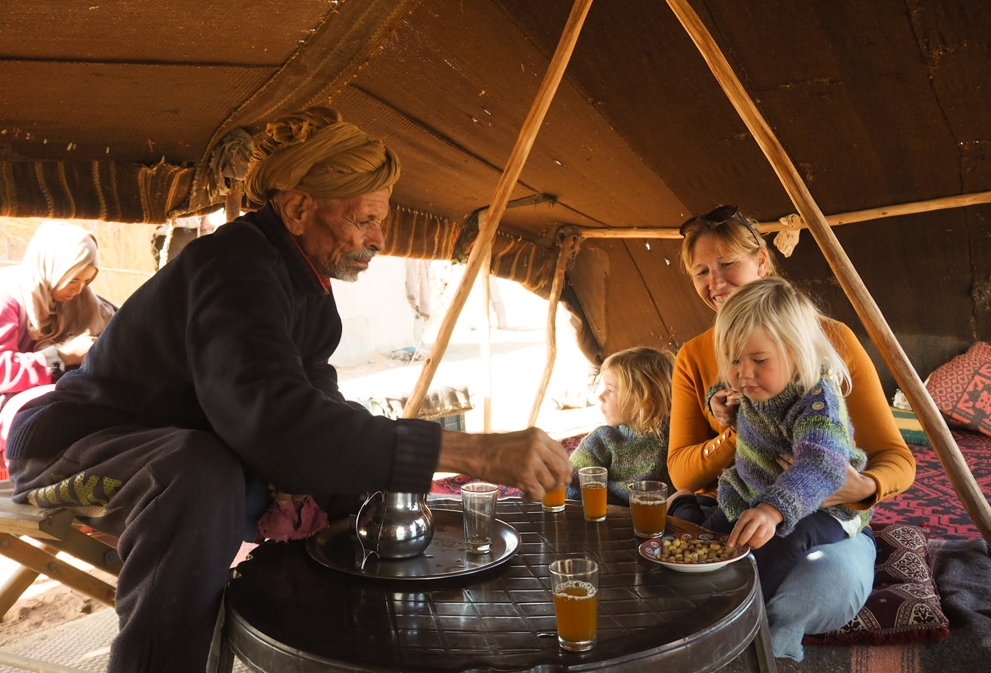 Family of visitors enjoying mint tea inside a Berber Nomad tent