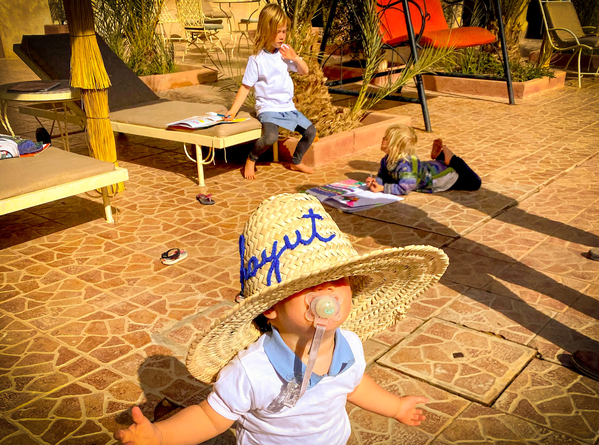 3 small children relaxing at the Hotel Kasbah Moyahut, Merzouga, Morocco