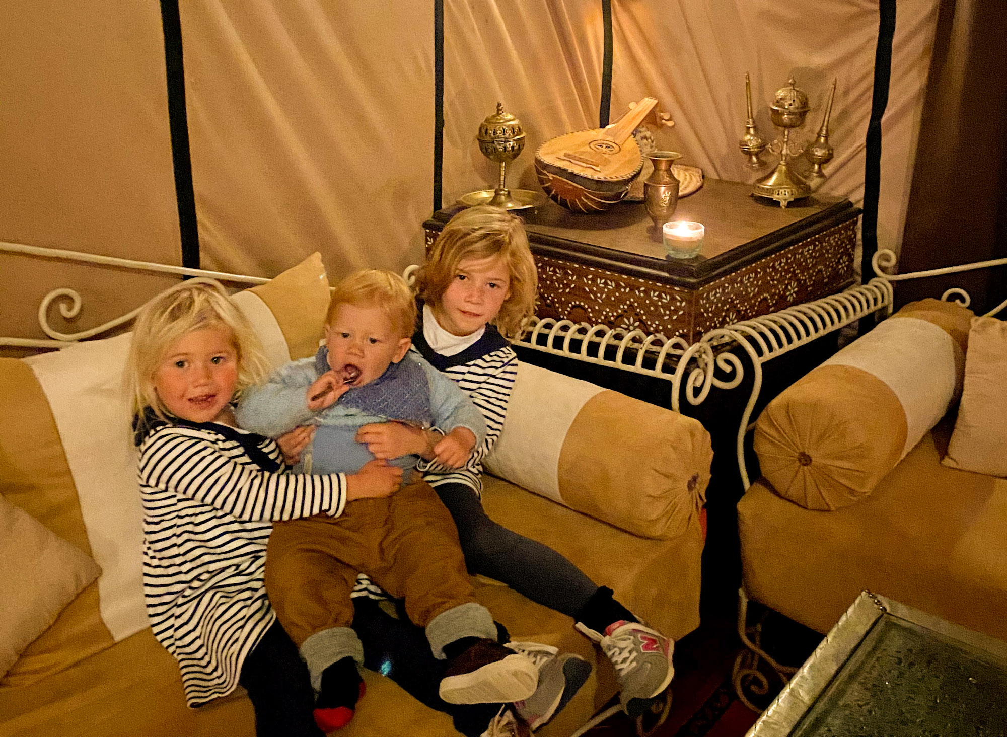 3 small children inside a luxury tent at Sahara Stars Camp, Merzouga, Morocco