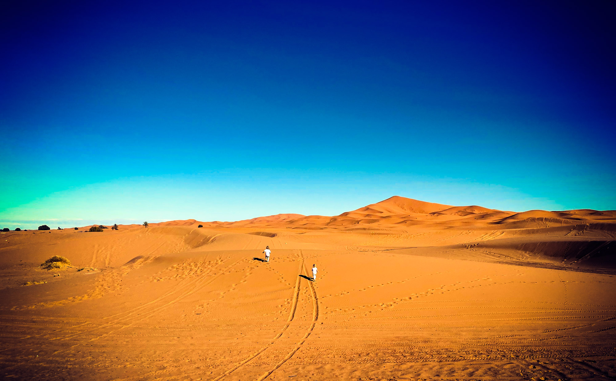 2 small children running into the desert at Merzouga, Morocco