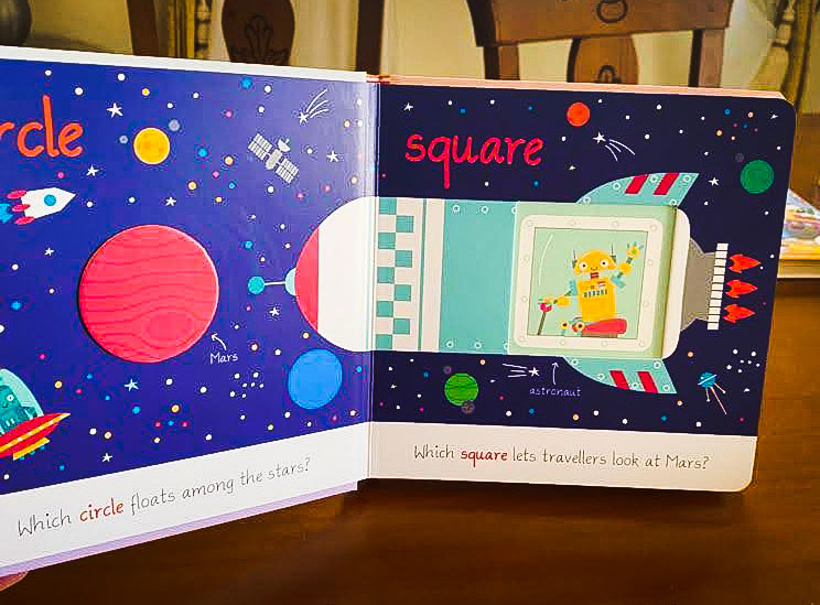 View of inside pages from a children's book, showing a colourful space rocket, with circle and square shapes