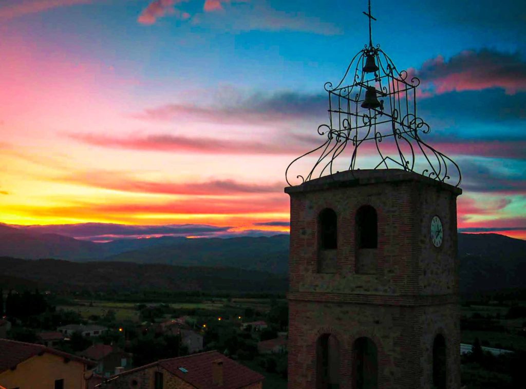 Church bell tower at sunset, in Joch, France.