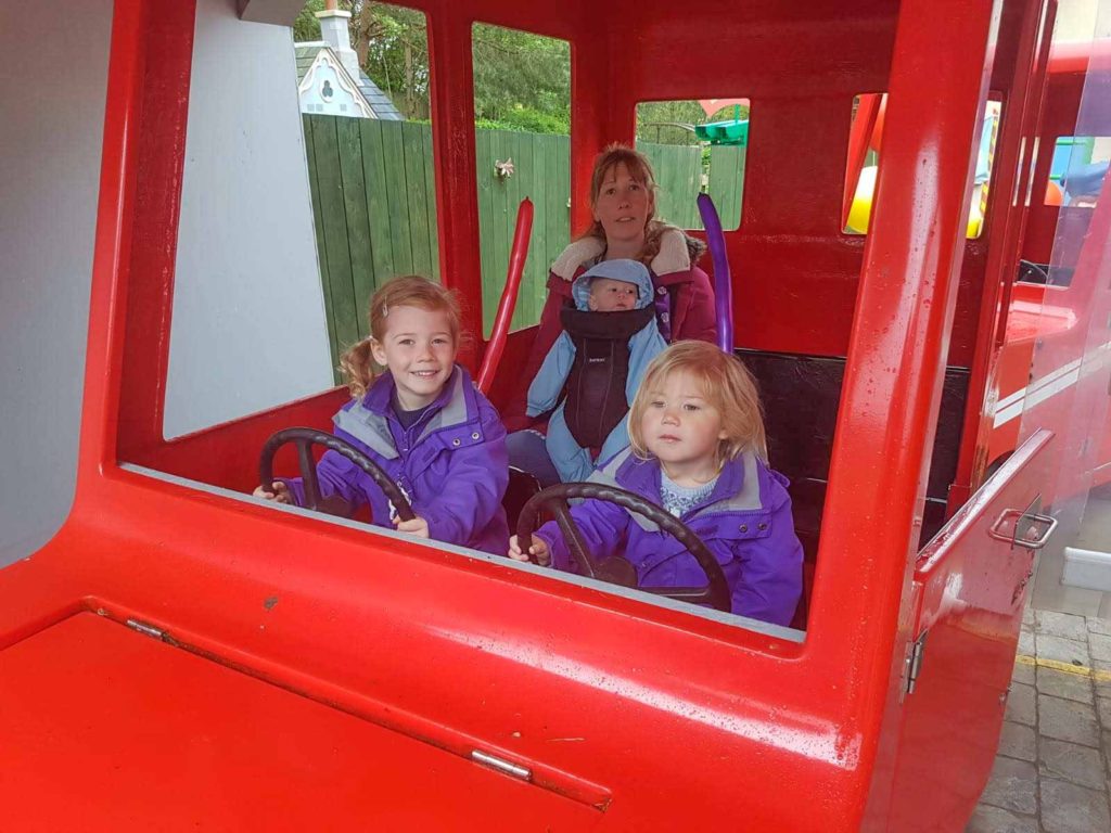 Family riding inside a red 'Postman Pat' car at Alton Towers theme park