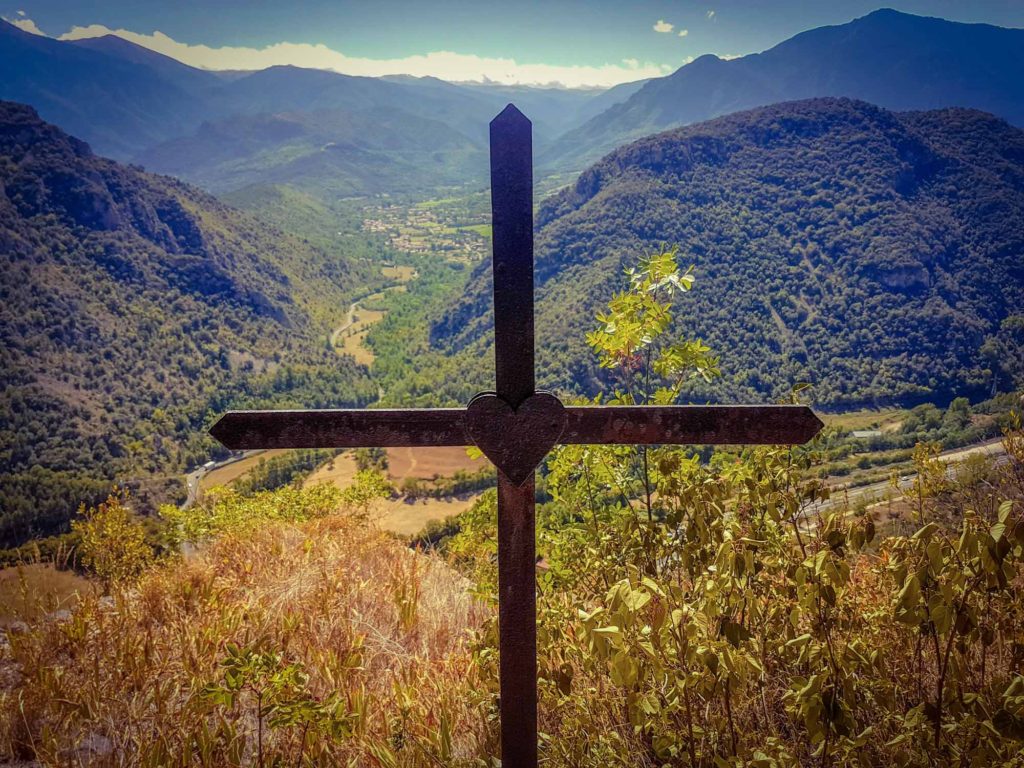 Iron cross with mountain landscape scenery behind