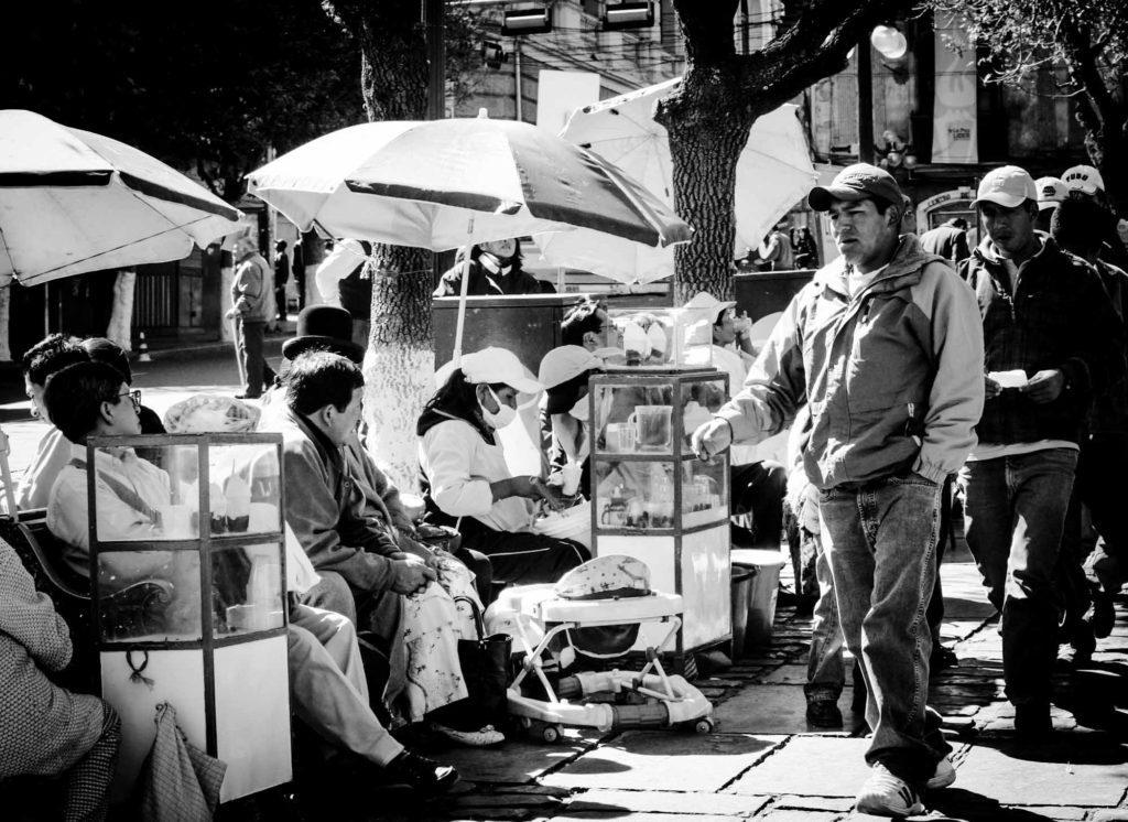 Line of street food sellers, sat under parosols, in La Paz, Bolivia