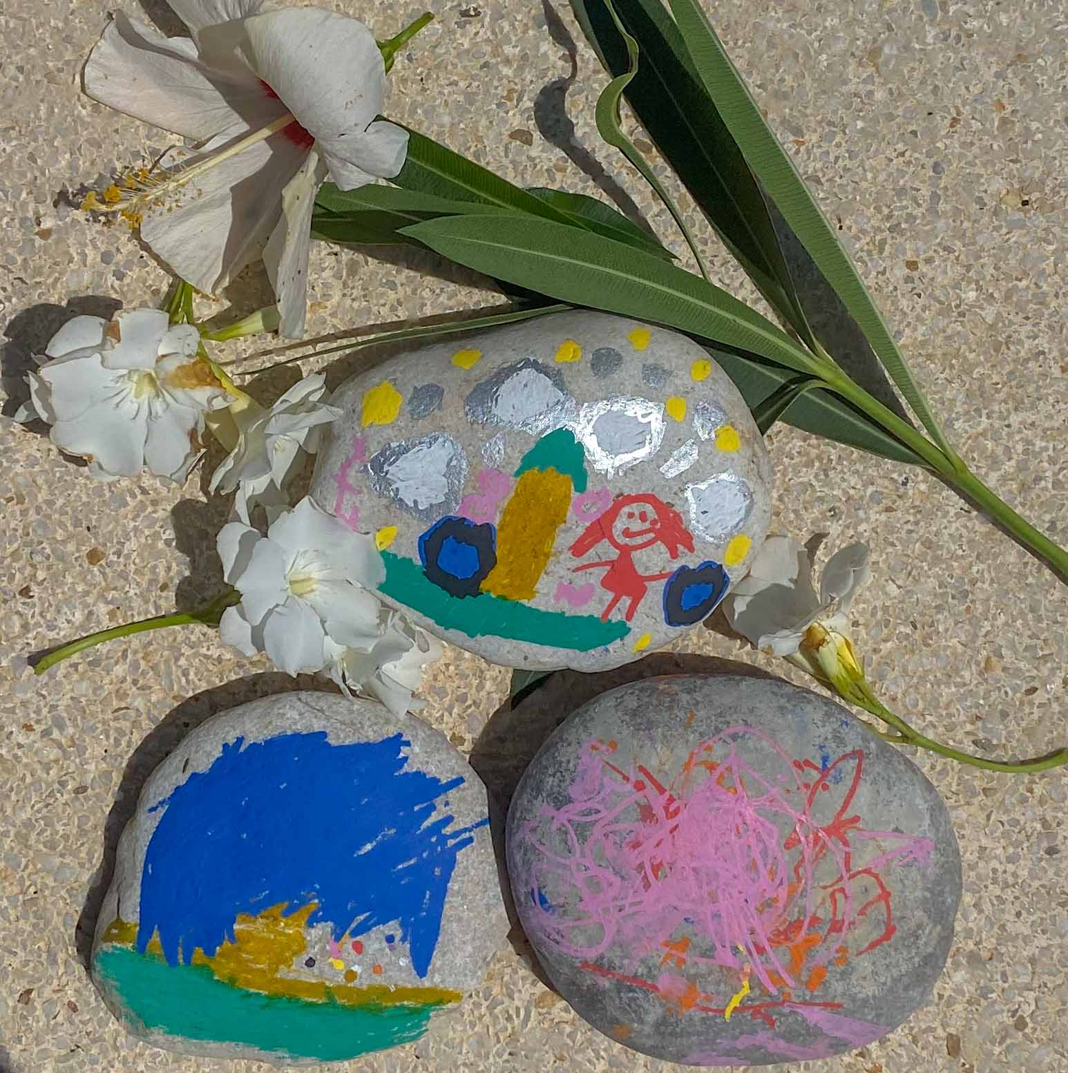 3 round stones that have been painted on by young children