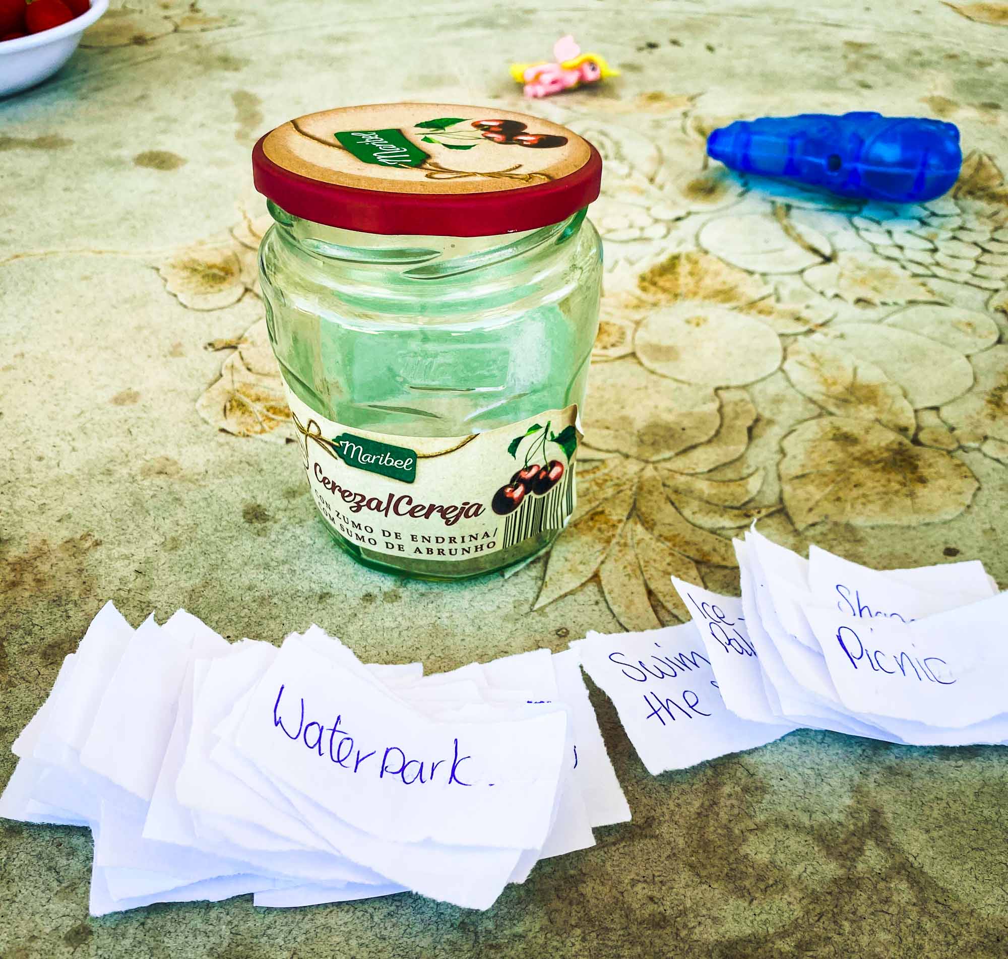 Empty jam jar being used to store pieces of paper with different children's activities written on them