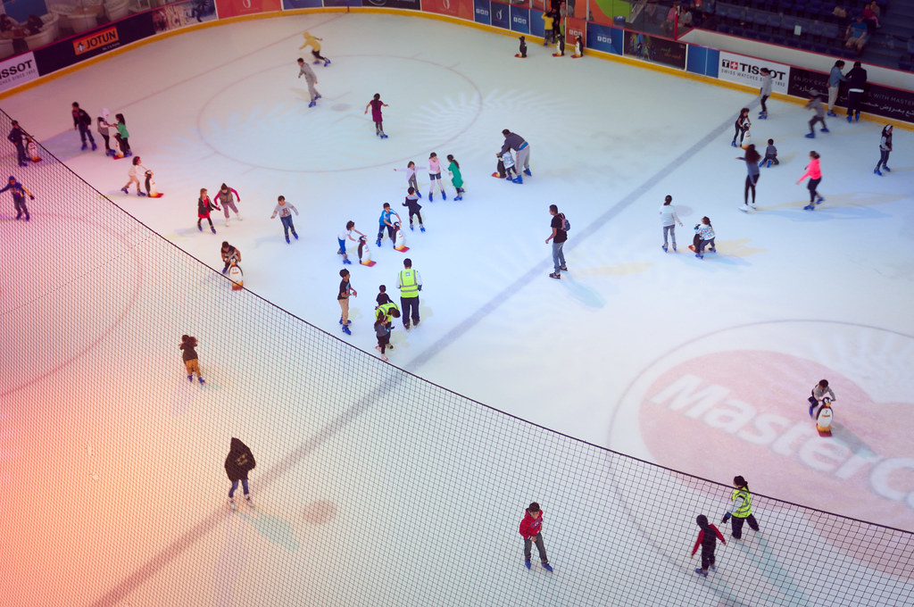 Overhead view of an ice rink with people skating on it