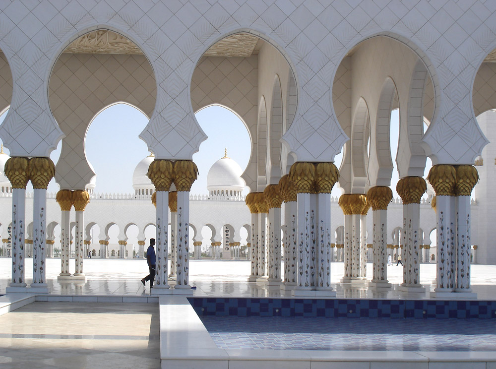 Intricately decorated, arch-topped columns surrounding an exterior courtyard at the Abu Dhabi Grand Mosque