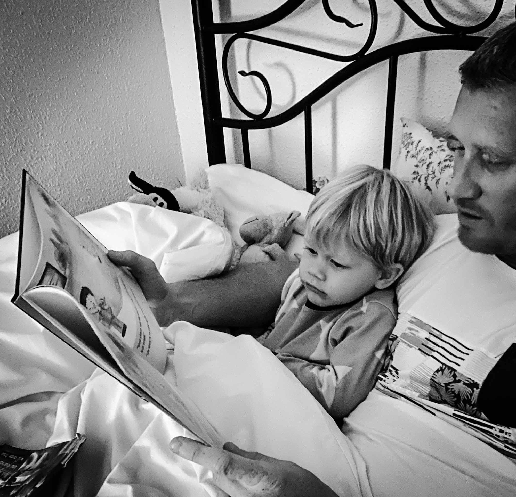Father reading his young son a bedtime story in bed