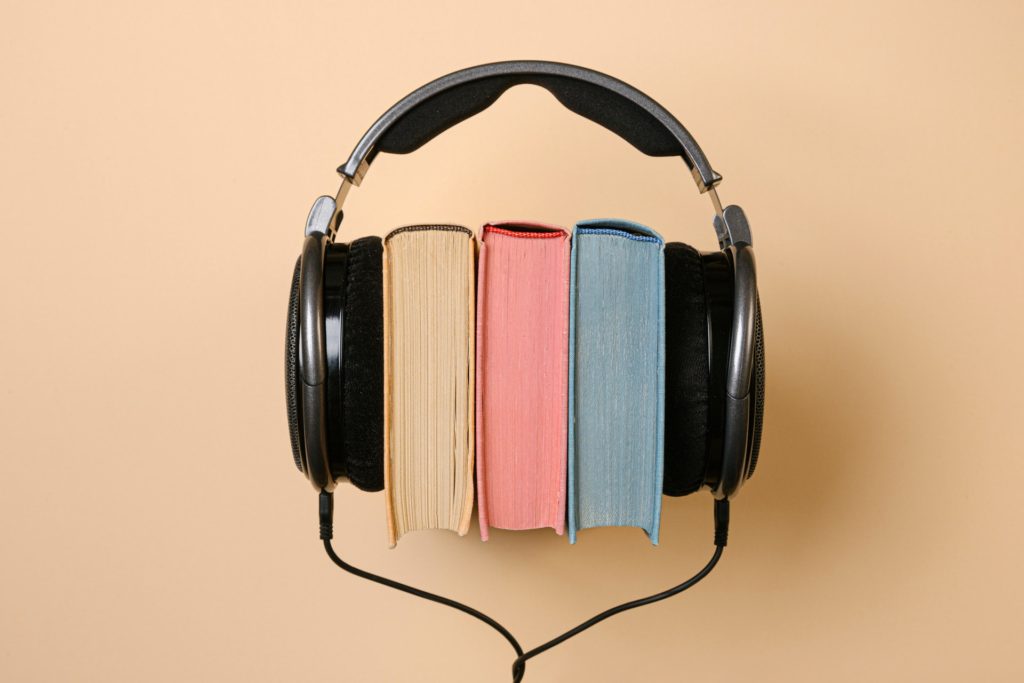 Set of over-ear headphones, with 3 hardback books sandwiched in the middle
