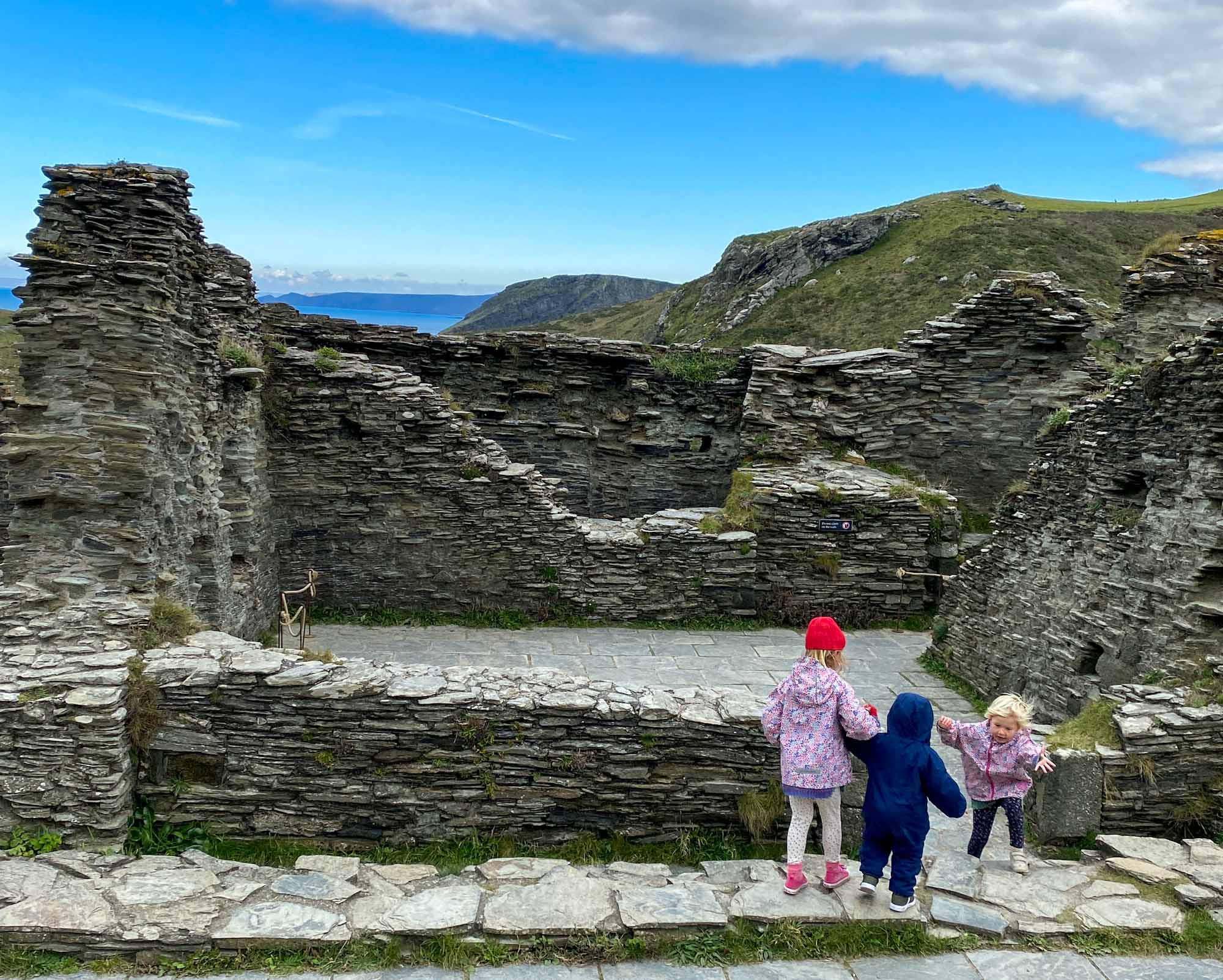 3 young children exploring shale stone castle ruins