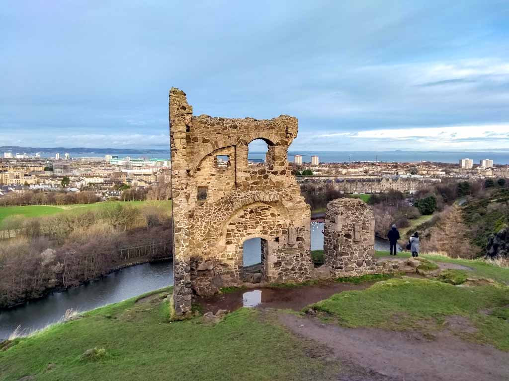 Ruins of a stone tower, on a hillside overlooking Edinburgh