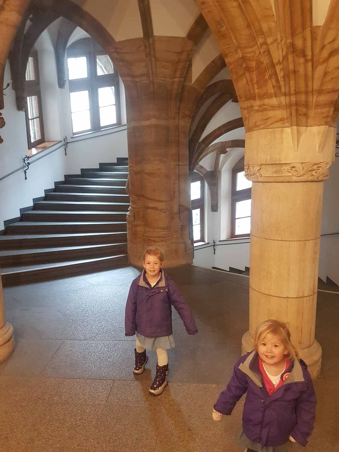 2 young girls exploring a stone spiral staircase, with vaulted ceiling