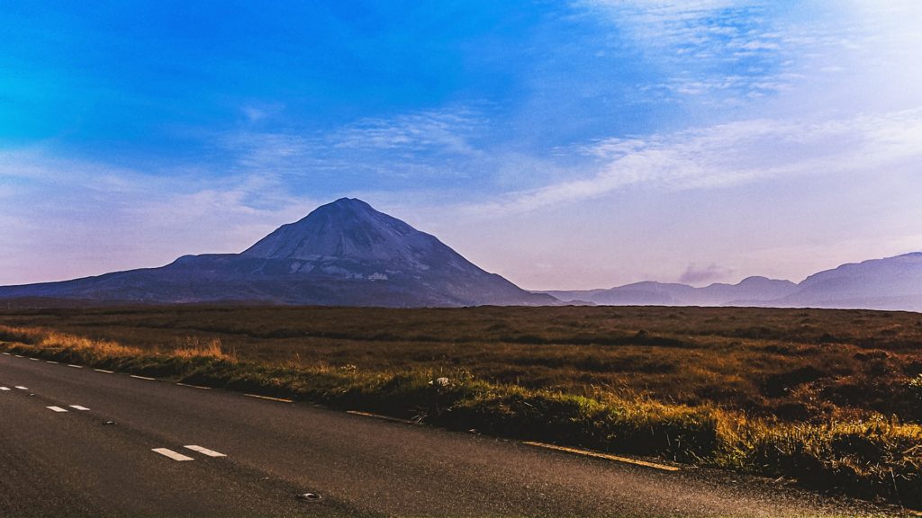 Country road in Ireland, with a conical mountain behind
