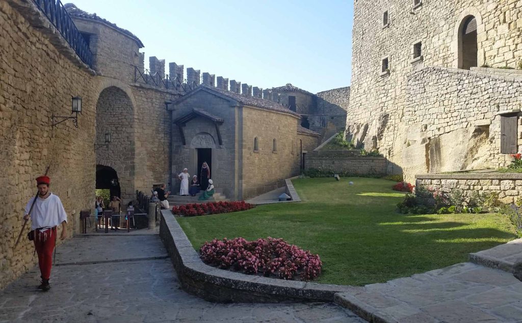 A medieval castle courtyard, with actors in period dress