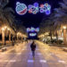 Lady stood under Christmas lights on the Balcon de Europa, Nerja, Spain